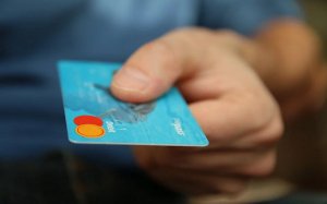 tarjeta de crédito a punto de pagar en un establecimiento, como un bar o una tienda