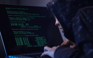 computer hacker in hooded shirt typing software algorithms and stealing data from computer network on laptop (1)