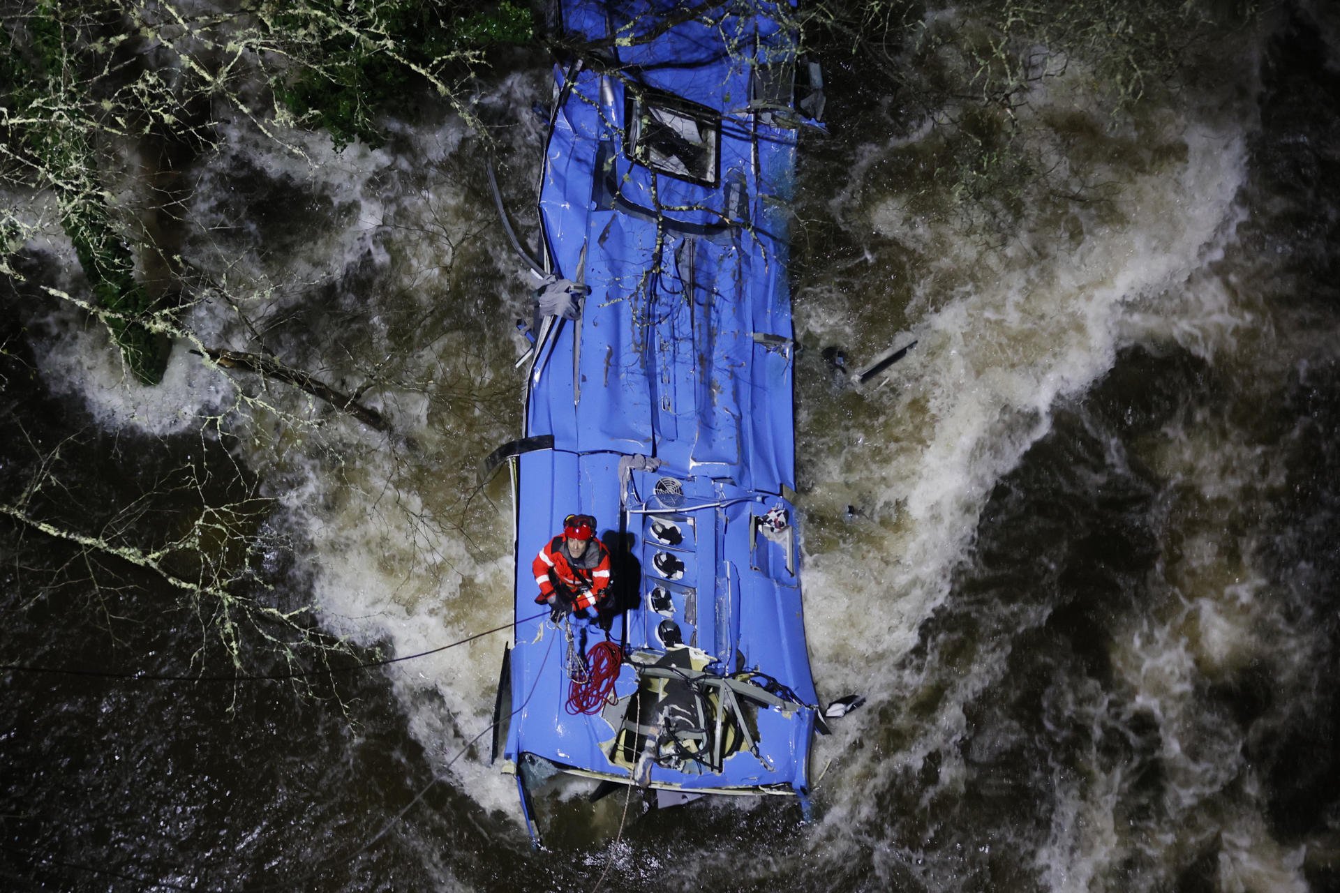 Los equipos de rescate sobre el autobús que ha caído al río en Galicia esta nochebuena / EFE-Lavandeira jr