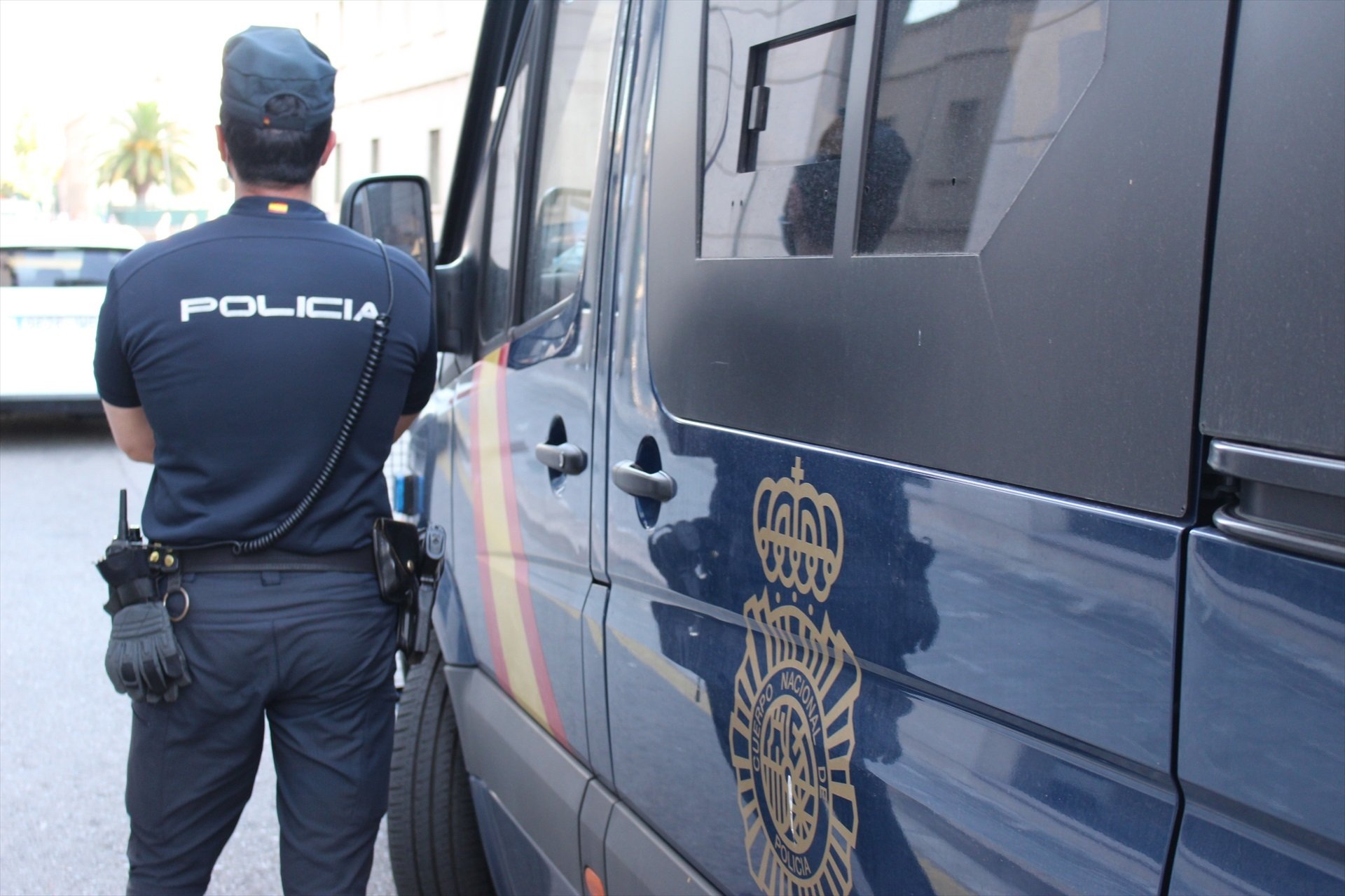 Un agent de la Policia Nacional al costat d'una furgoneta del cos, en una imatge d'arxiu / POLICIA NACIONAL