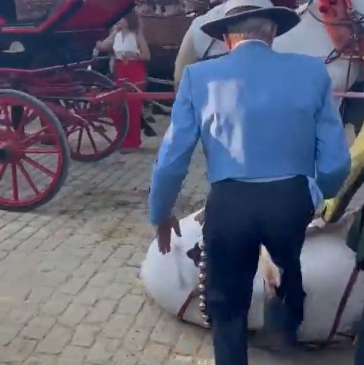 Un dels homes donant puntades de peu al cavall a la Feria de Abril de Sevilla / @jonatan_lopez_