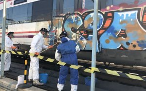 Operaris netegen un grafiti en un tren de Renfe a Madrid en una imatge d'arxiu / RENFE