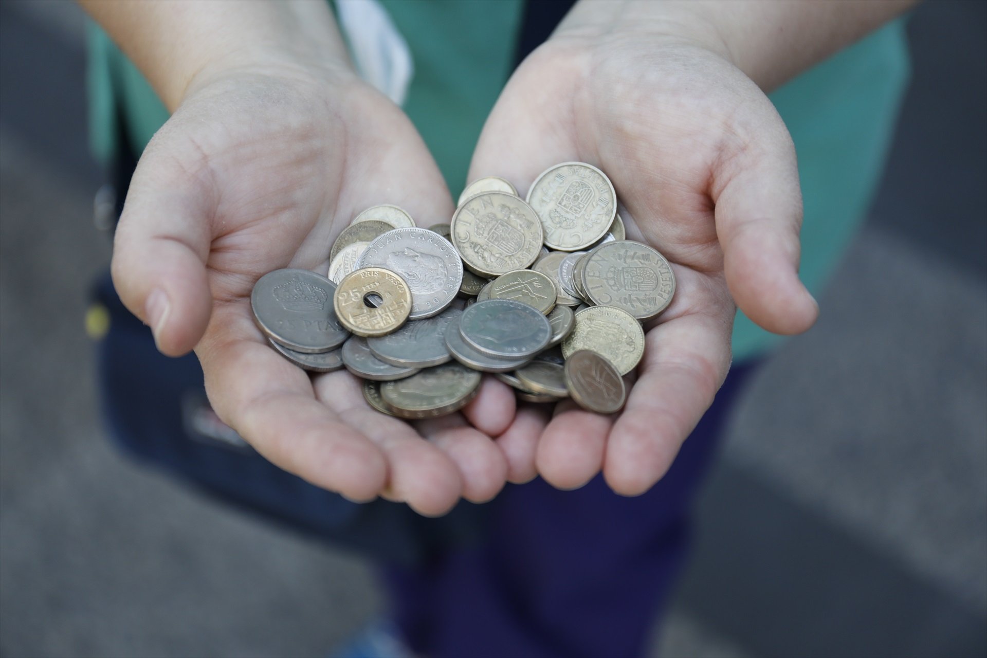 Una persona ensenya monedes de peseta en una imatge d'arxiu / Cézaro de Luca - Europa Press