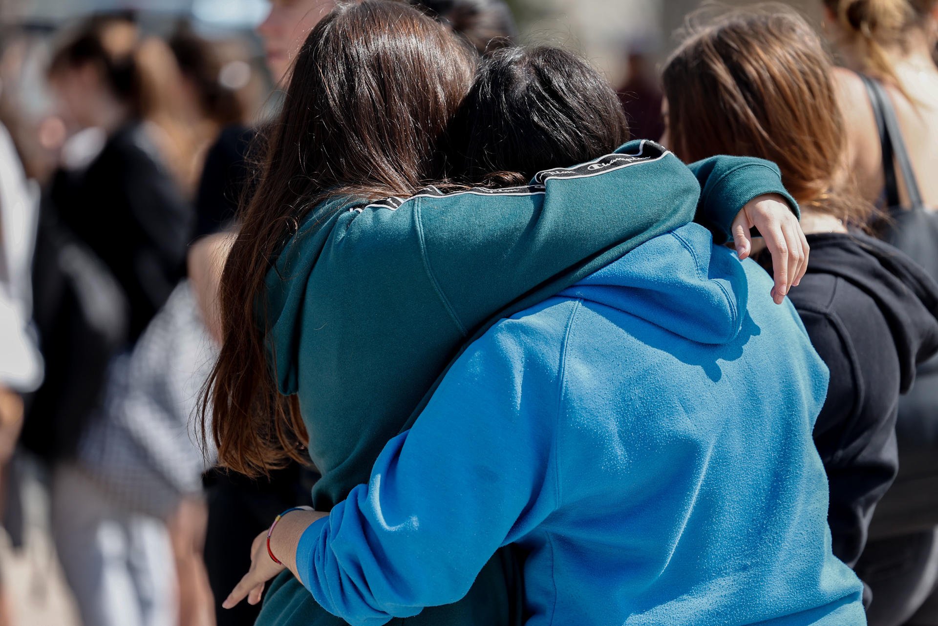 Abraçades entre companyes després del minut de silenci per la mort de les quatre joves en un accident de trànsit a Collado Villalba, a Madrid / SERGIO PÉREZ - EFE