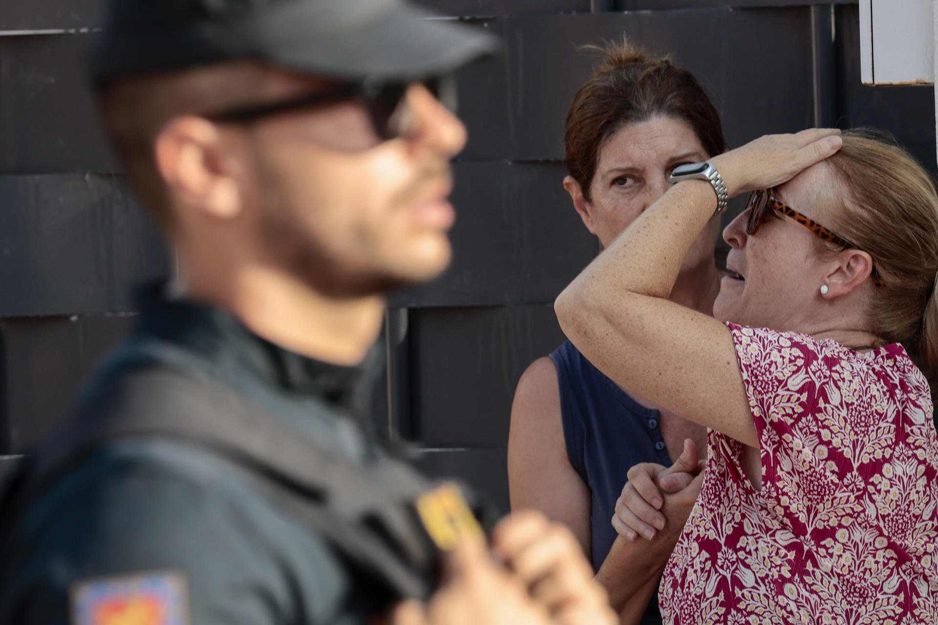 La Policía Nacional ha hallado los cadáveres de la mujer de 58 años y su exmarido, de unos 70 y policía retirado, que se había atrincherado con ella como rehén en una vivienda de Alzira (Valencia).En la imagen, amigas y vecinas de la fallecida en las inme