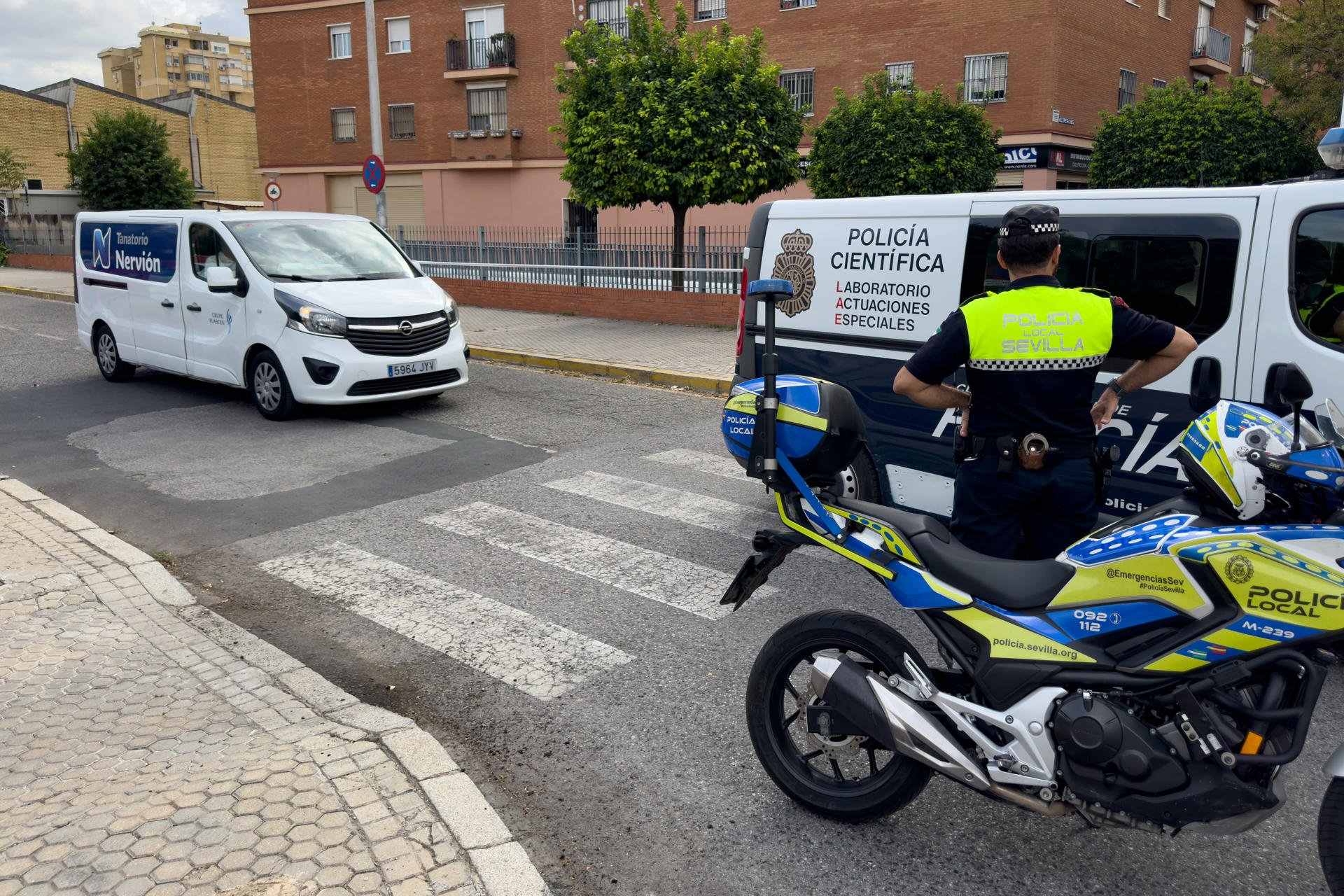 Policia Científica de la Policia Nacional i agents de la Policia Local de Sevilla amb una vehicle funerari després de fer l'aixecament del cadàver a Sevilla / DAVID ARJONA - EFE