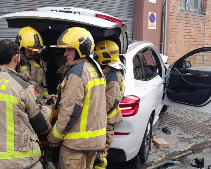 Els bombers en el moment d'excarcerar el conductor que ha impactat amb el seu cotxe contra un edifici a l'Hospitalet / BOMBERS DE LA GENERALITAT