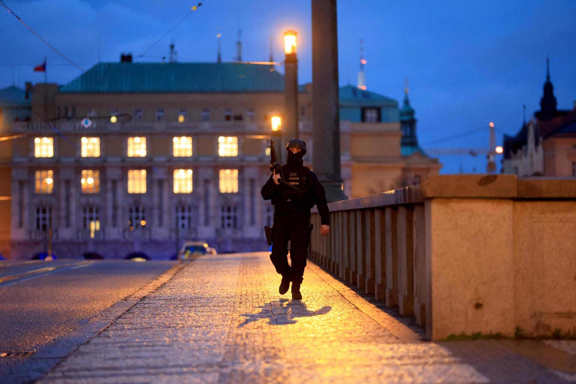 Un policía armado muy cerca de la zona del tiroteo de Praga - Los bomberos en la zona del tiroteo en Praga - Un agente de policía en el cordón de seguridad busca del lugar del tiroteo en lo centro de Praga - EFE/EPA/MARTIN DIVISEK 