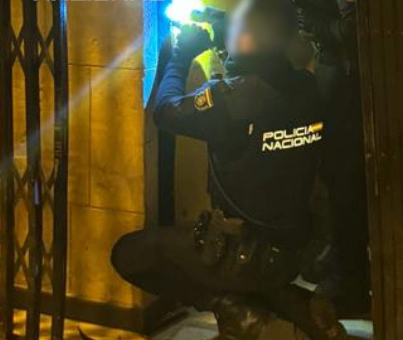 La Policía Nacional al llegar al bar de Elche donde se ha quedado atascado el ladrón en la ventana / CNP
