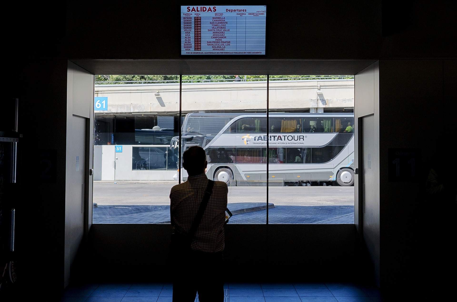Una persona mira el panel con un autobús al fondo en la estació Sur de Méndez Álvaro de Madrid / Alberto Ortega - Europa Press