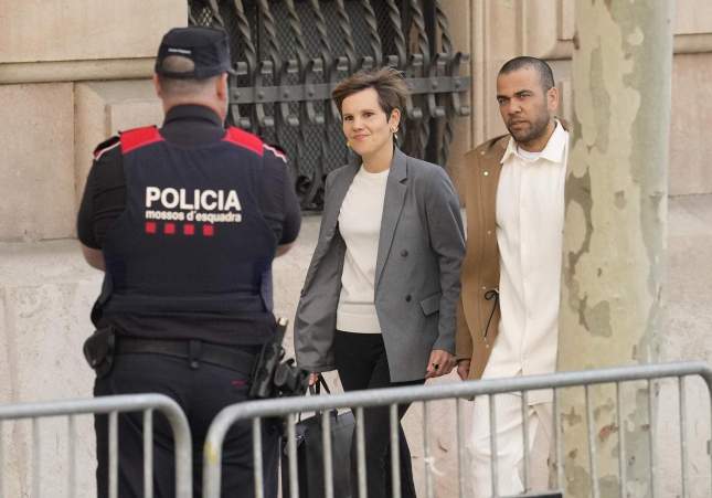 Dani Alves i la seva advocada passen al costat d'un agent dels Mossos d'Esquadra abans d'entrar a l'Audiència de Barcelona / Enric Fontcuberta, EFE