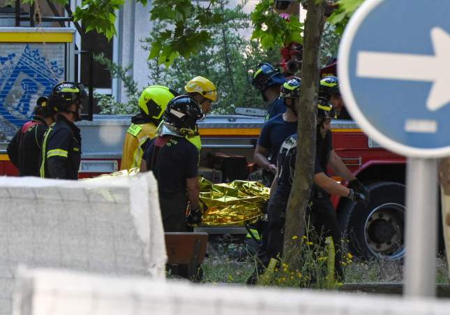 Un grup de bombers mou un dels cossos sense vida dels treballadors / Fernando Villar, EFE