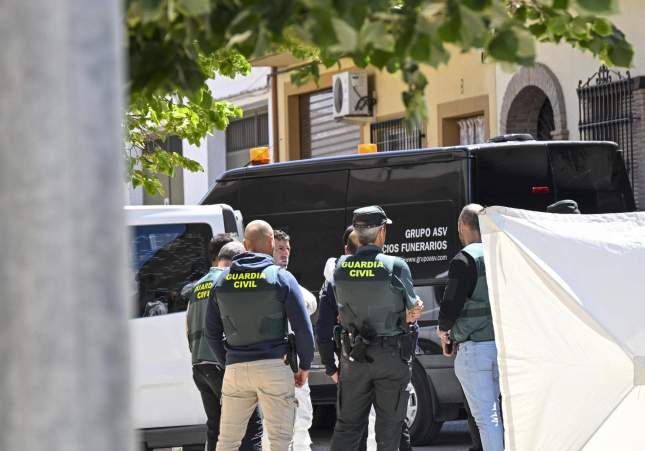  Agentes de la Guardia Civil entre otras personas esperan a la puerta de la vivienda la salida del coche fúnebre con los cuerpos del hombre de 72 años que permanecía atrincherado con un arma de fuego desde la noche de ayer domingo junto a sus dos nietos, de 10 y 12 años, a los que ha matado y luego se ha suicidado, este lunes en la localidad granadina de Huétor Tajar / Miguel Ángel Molina, EFE