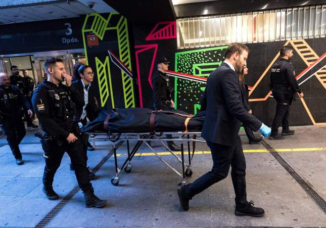 Personal de una funeraria transportan el cuerpo de la fallecida, en la Plaza de los Cubos de Madrid, custodiados por la Policía Nacional / Diego Radamés, Europa Press