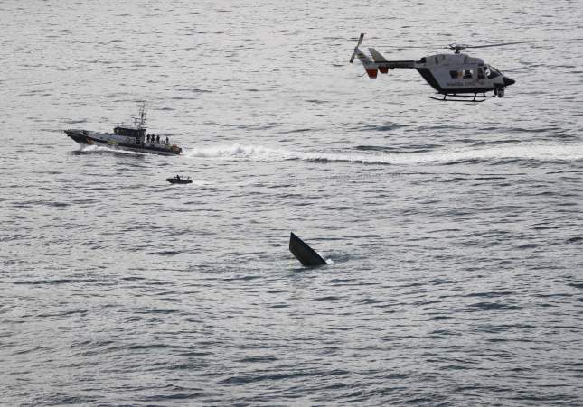 la proa de la embarcación sobresale en la ría entre los concellos coruñeses de Camariñas y Muxía, vigilado por un helicóptero y una embarcación de la Guardia Civil, además de la zodiac desde la que se sumergieron buzos del Instituto Armado. EFE/Cabalar