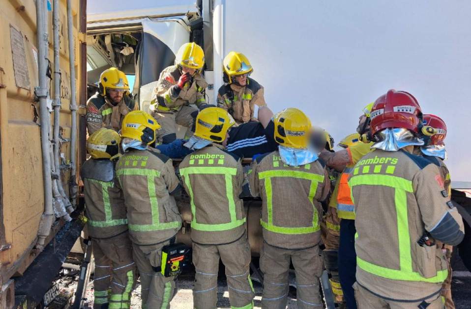 Bombers amb el camioner accidentat Bombers amb el camioner accidentat
